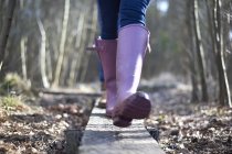 Female legs in gumboots in forest — Stock Photo