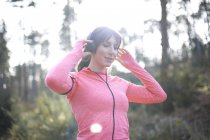 Woman prepares to go for run in woods — Stock Photo