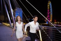 Couple run across Millennium Bridge — Stock Photo