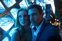 Casal banhado em luz azul na frente da luminária — Fotografia de Stock