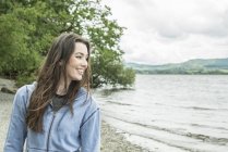 Женщина, стоящая на берегу и улыбающаяся — стоковое фото