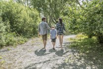 Man and woman with boy walking on path — Stock Photo