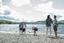 Familia de cinco de pie en la orilla - foto de stock