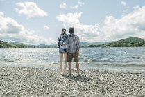 Uomo e donna che si tengono per mano sulla riva — Foto stock