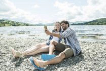 Homem e mulher tomando selfie na costa — Fotografia de Stock