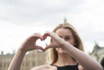 Mujer hace forma de corazón con las manos - foto de stock
