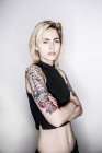 Татуированная женщина позирует в студии — стоковое фото