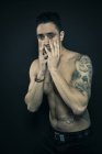 Uomo tatuato che copre il viso con le mani — Foto stock