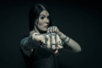 Portrait of woman with tattooed arms and face — Stock Photo