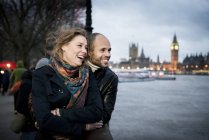 Couple standing looking across River Thames — Stock Photo