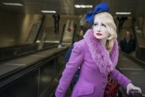 Mujer en las escaleras mecánicas del metro de Londres - foto de stock