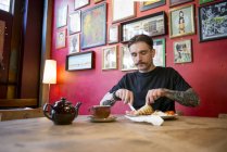 Чоловік їсть у кав'ярні — стокове фото