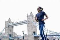 Man jogging past Tower Bridge — Stock Photo