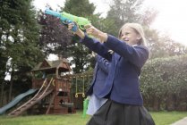 Девушка стреляет из двух водяных пистолетов — стоковое фото