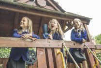 Meninas ficar em aparelhos de parque infantil de madeira — Fotografia de Stock