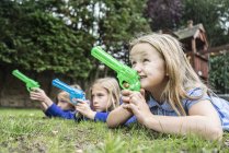 Девушки играют с водяными пистолетами — стоковое фото