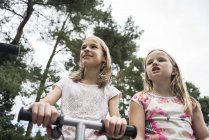 Girls playing on scooter outside — Stock Photo
