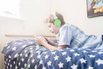 Niño escuchando música en auriculares - foto de stock