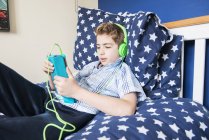 Хлопчик слухає музику в навушниках — стокове фото