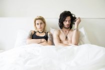 Пара, лежащая в двуспальной кровати после спора — стоковое фото