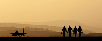 Silhuetas de tripulação militar caminhando — Fotografia de Stock