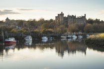 Castello medievale visto attraverso il fiume al tramonto — Foto stock