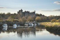 Середньовічний замок переглядали через річки на заході сонця — стокове фото