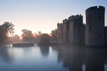 Beautiful medieval castle and moat at sunrise — Stock Photo