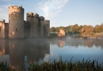 Красивый средневековый замок и ров на рассвете — стоковое фото