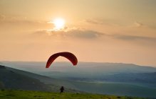 Paraglider takes off into setting sun — Stock Photo