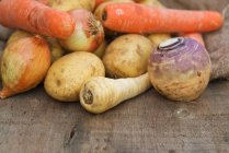 Cenouras e batatas na mesa de madeira — Fotografia de Stock