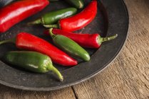 Red and green peppers on plate — Stock Photo