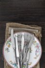 Vintage cutlery and crockery on cloths — Stock Photo