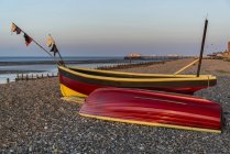 Petits bateaux de pêche sur la plage au lever du soleil — Photo de stock
