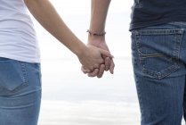 Couple holding hands on beach — Stock Photo