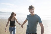 Пара, держащаяся за руки на пляже — стоковое фото