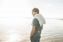 Чоловік насолоджується сонячним світлом на пляжі — стокове фото