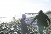 Пара ходить, тримаючи руки на пляжі — стокове фото