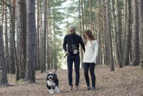 Coppia fuori con cane sulla passeggiata nella foresta — Foto stock