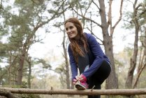 Woman preparing to go for jog through forest — Stock Photo