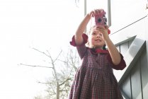 Menina tirando foto com câmera de brinquedo — Fotografia de Stock