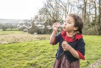 Mädchen pustet Blasen im Garten — Stockfoto