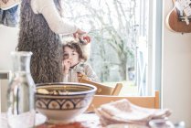 Junge steht in Küche neben Mutter — Stockfoto