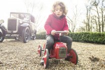 Garçon assis sur le tracteur jouet — Photo de stock