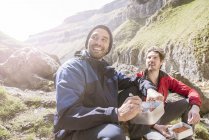 Альпіністи сидять і їдять їжу — стокове фото