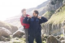 Mountaineer helping friend with rucksack — Stock Photo