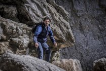 Alpinista in piedi sopra le rocce in terreni accidentati — Foto stock