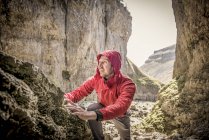 Bergsteiger klettert in unwegsamem Gelände über Felsen — Stockfoto