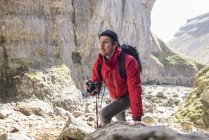 Alpiniste grimpant sur les rochers et prenant des photos — Photo de stock