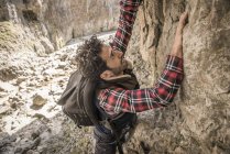 Alpinista che attraversa la sporgenza rocciosa — Foto stock
